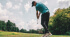En person gör ett golfslag på en golfbana