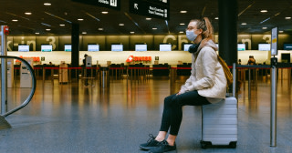 tjej med munskydd på flygplats