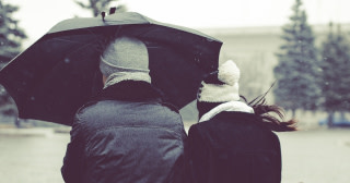 två personer under ett paraply i snöväder