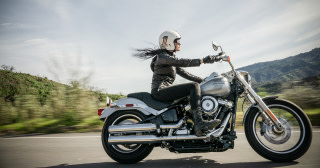 Kvinna som kör motorcykel i bergigt landskap